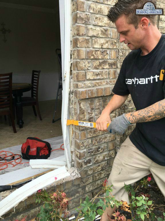 This is a shot of the nailing fin behind the brick and its removal on a replacement window installation